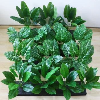 Изкуствено широколиственное растение монстера подорожниковая, тропически живовляк, зелен бонсай със зелени листа Изображение